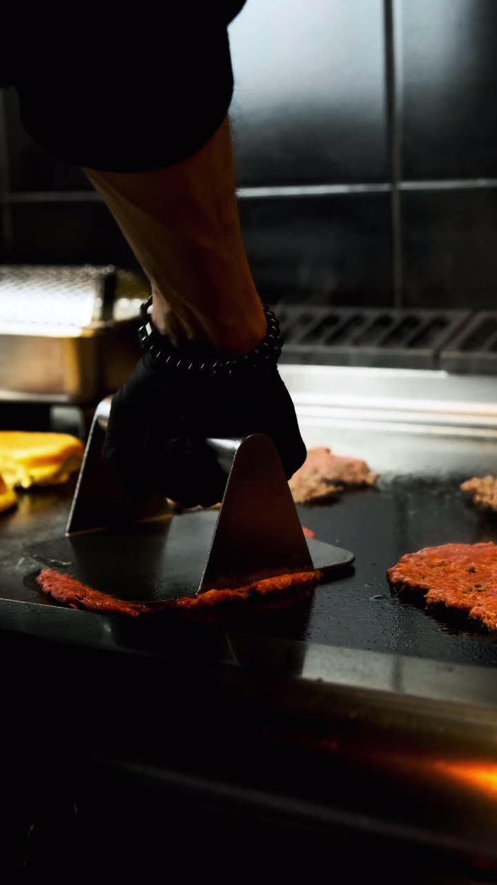 Loop aus der Küche: Patties werden auf der Grillplatte flachgedrückt
